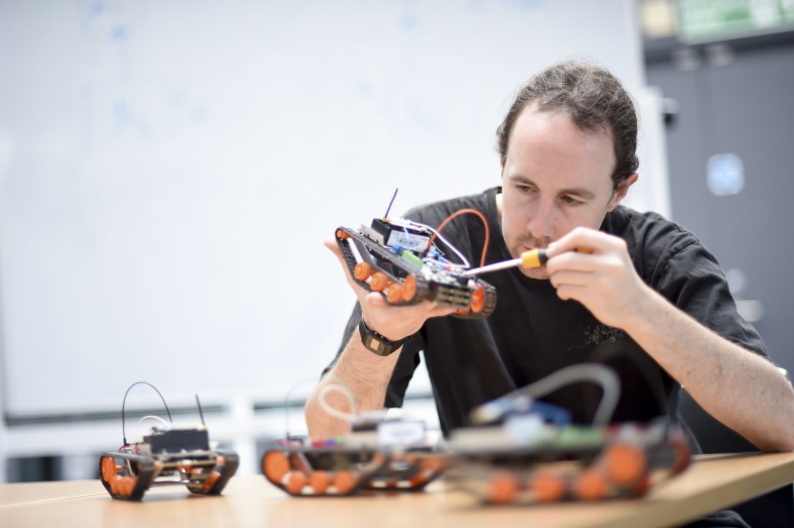 A PhD student works on mini-robots for his robotics project at the СƵ
