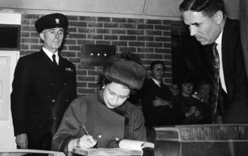 The Queen signing a document at the СƵ