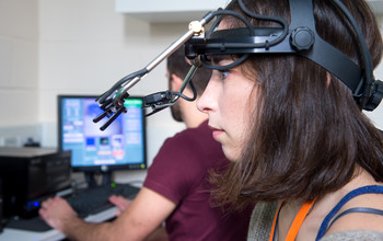 A researcher using psychology equipment at the СƵ